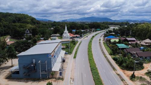 an aerial view of a town with a road and a church at A Hotel Cozy in Ban Pa Sak
