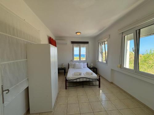 a bedroom with a bed and a large window at United blue Resorts - White Sand in Karteros
