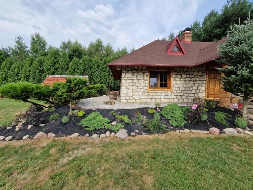 a small house with a rock garden in front of it at Harcówka in Miękisz Nowy