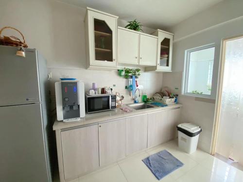 a kitchen with white cabinets and a microwave at Nautilus Bay Home Inn in George Town