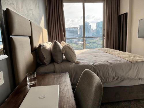 Cette chambre comprend un lit avec une table et une fenêtre. dans l'établissement The Capital in Sandton-Luxury aparthotel, à Johannesbourg