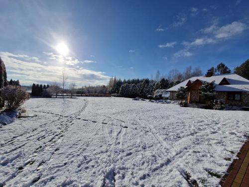 a snow covered field with the sun in the sky at Harcówka in Miękisz Nowy