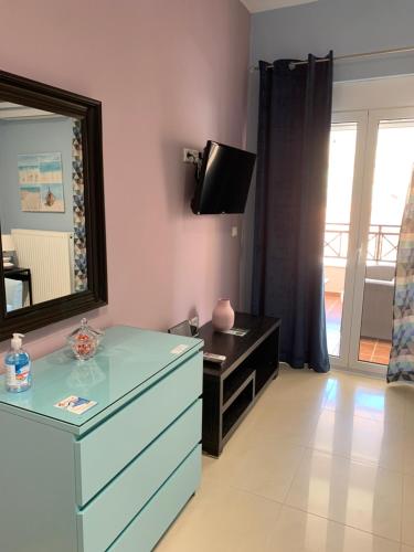a living room with a dresser and a mirror at Christi Apartments Α&Β in Kokkíni Khánion