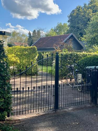 a black wrought iron gate with a bicycle behind it at The Pool House in Den Dolder