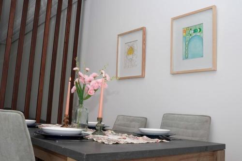 a dining room table with a vase of flowers on it at Appartement Moderne au Cœur de Rabat in Océan