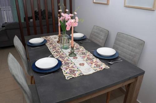 a table with plates and a vase of flowers on it at Appartement Moderne au Cœur de Rabat in Océan