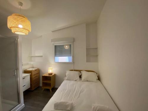 une chambre avec un lit, un bureau et une fenêtre dans l'établissement Le Bali, Magnifique T2, centre ville 1 er etage, à Valence