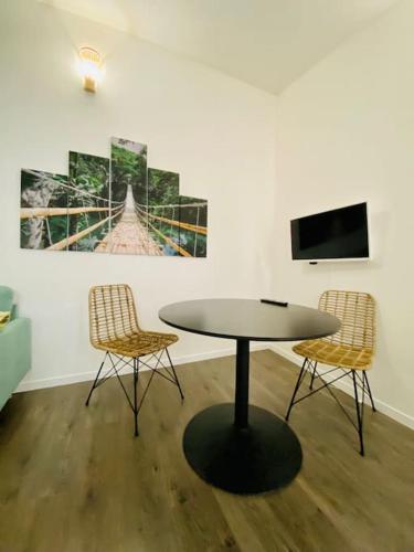 - une table dans une chambre avec 2 chaises et une télévision dans l'établissement Le Bali, Magnifique T2, centre ville 1 er etage, à Valence