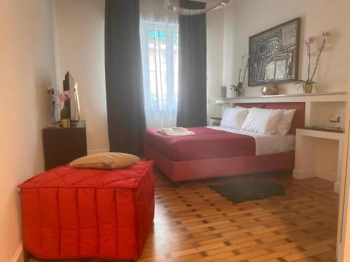a bedroom with a bed and a red ottoman at Maison d'Or in Genova