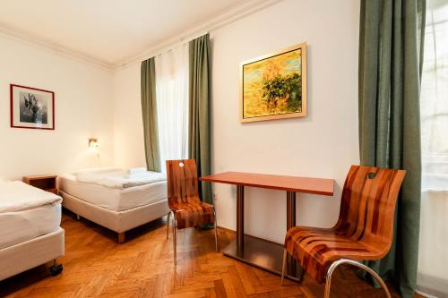 a hotel room with a bed and a table and chairs at Penzion Pod Lipo in Ljubljana