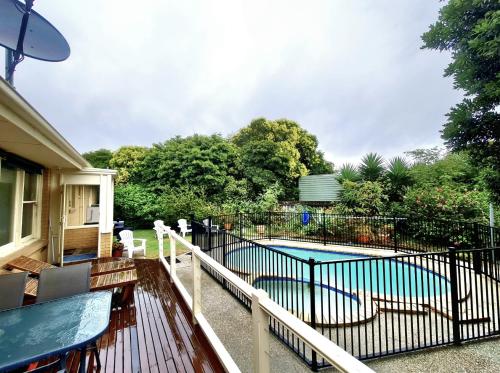 a balcony with a pool with chairs and a fence at Waterfront Quiet Stay off Geelong & Avalon Airport in North Shore