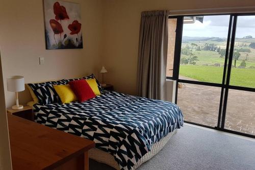 a bedroom with a bed and a large window at Country Getaway House in Port Albert