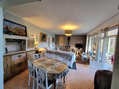 un salon avec une table et une salle à manger dans l'établissement Parenthèse Océane Suite calme 1 ou 2 chambres entre bois et mer, à Perros-Guirec