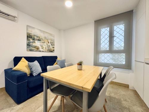 a living room with a table and a blue couch at Hotel Apartamentos Marina Luz in Chipiona