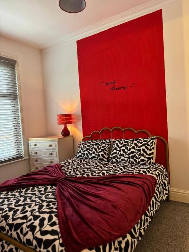 a bedroom with a bed with a red headboard at Quirky House Blackpool in Blackpool