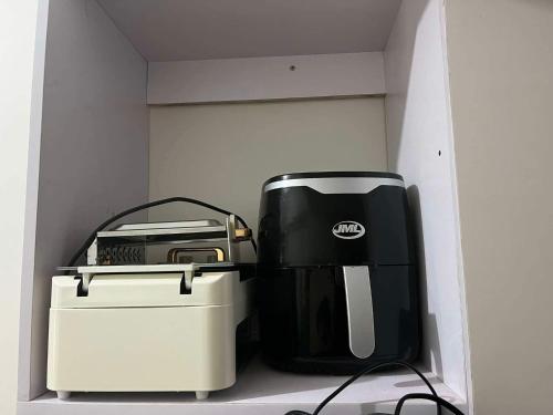 a coffee maker and toaster sitting on a shelf at Chill in Peace Staycation 2BR condo at Field Residences, Sucat near NAIA in Manila