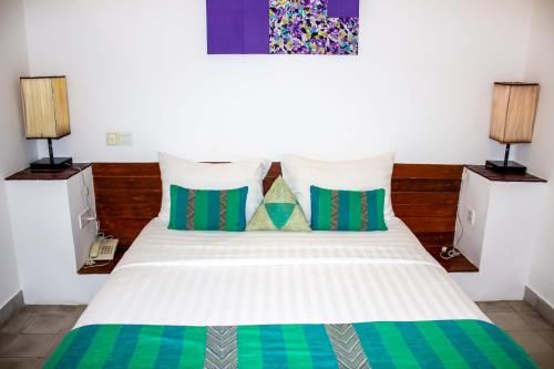a bedroom with a bed with two night stands and two lamps at House Boutique Eco Hotel in Phnom Penh