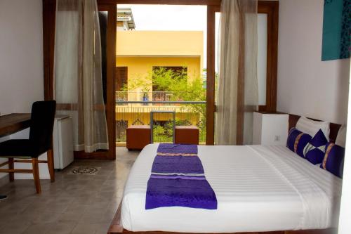 a bedroom with a large bed and a window at House Boutique Eco Hotel in Phnom Penh
