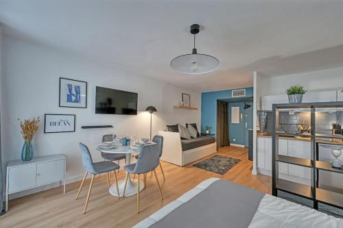 un salon avec une table, des chaises et un canapé dans l'établissement 063 - Studio Didion, Centre Gare St Roch, Clim, Balcon,4pers, à Montpellier