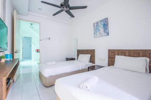 a hotel room with two beds and a ceiling fan at Nautilus Bay Home Inn in George Town
