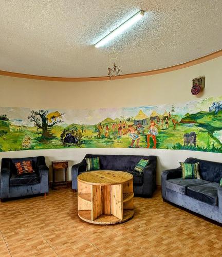 a living room with couches and a painting on the wall at Acacia Villa Kampala in Kampala