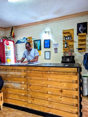 a man standing at the counter of a restaurant at Acacia Villa Kampala in Kampala