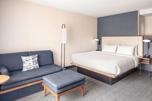 a hotel room with a bed and a couch at Courtyard Portland Airport in South Portland