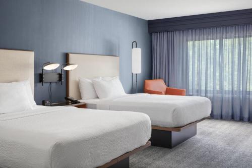 a hotel room with two beds and a window at Courtyard Portland Airport in South Portland