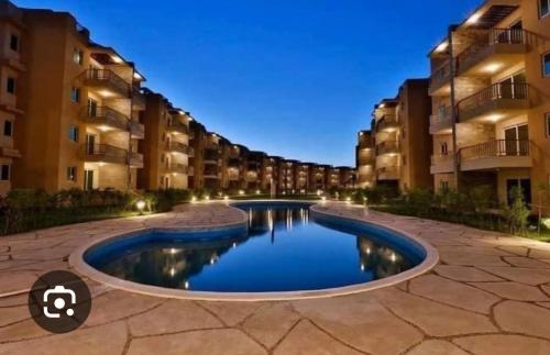 a swimming pool in a courtyard of a building at New villa on the marina sea in Ash Shihābīyah