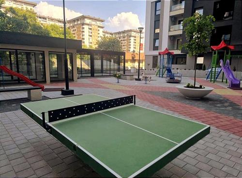 a tennis court in a courtyard with a playground at Apartman1105 Sarajevo Free Garage in Sarajevo