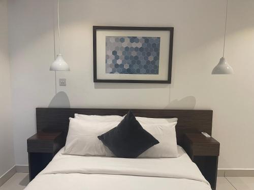Ένα ή περισσότερα κρεβάτια σε δωμάτιο στο Embassy Apartments