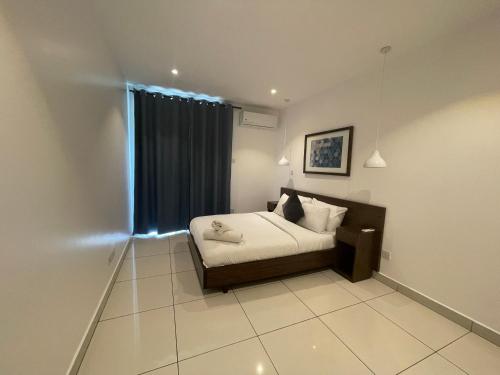 Ένα ή περισσότερα κρεβάτια σε δωμάτιο στο Embassy Apartments