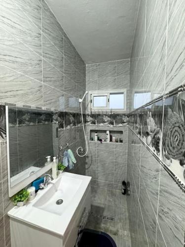 a bathroom with a sink and a shower and a mirror at le petit paradis in Chaba Remada