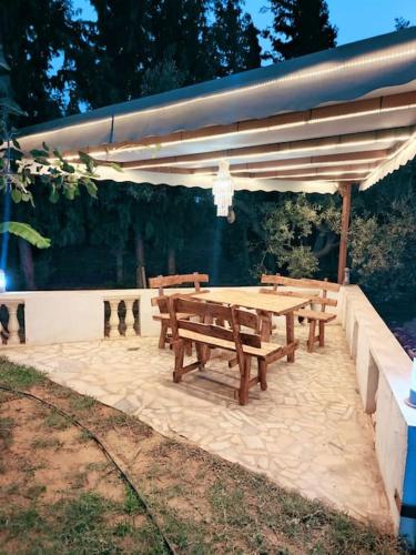 a picnic table with benches under a canopy at le petit paradis in Chaba Remada