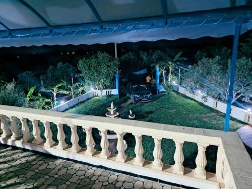 a fence in front of a garden at night at le petit paradis in Chaba Remada