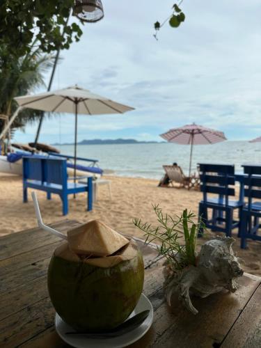 a coconut on a table next to the beach at Surf Beach House Pool Villa in Na Jomtien