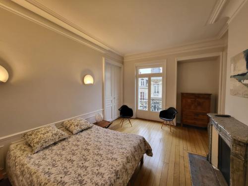 une chambre avec un lit, une télévision et une fenêtre dans l'établissement Center of Reims - Large refurbished historic flat, à Reims