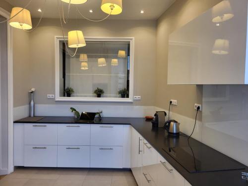 une cuisine avec des armoires blanches et une fenêtre dans l'établissement Center of Reims - Large refurbished historic flat, à Reims