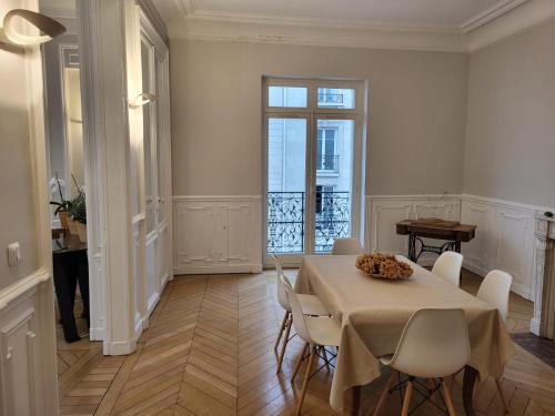 une salle à manger avec une table et des chaises blanches dans l'établissement Center of Reims - Large refurbished historic flat, à Reims