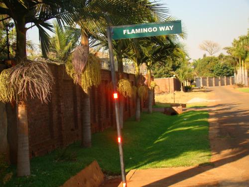 a street sign for flamingo way on a street at Pomona BB House in Harare