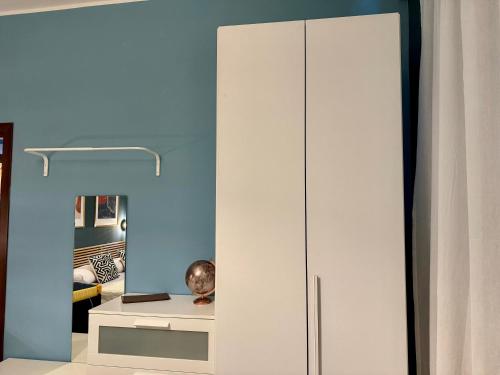 a white cabinet in a room with a mirror at B&B La Borasca - Apartments in Casalpusterlengo
