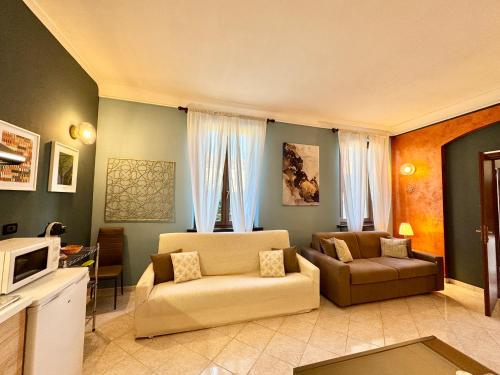 a living room with two couches and a tv at B&B La Borasca - Apartments in Casalpusterlengo