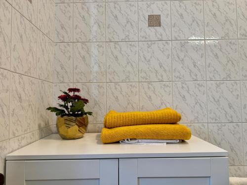 a table with a yellow blanket and a vase of flowers at B&B La Borasca - Apartments in Casalpusterlengo
