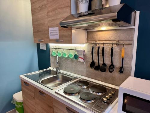 a kitchen with a sink and a stove with utensils at B&B La Borasca - Apartments in Casalpusterlengo