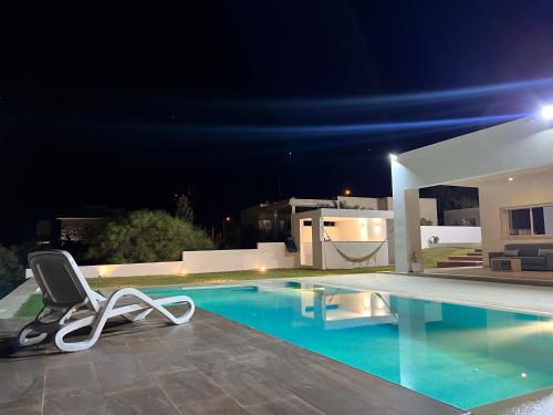 a swimming pool at night with a chair next to it at Villa ALKANTARA - 4 Bedroom in Ouled Yaneg