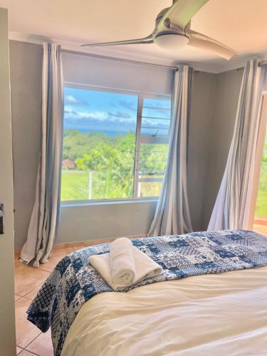 a bedroom with a bed with a large window at 6th Tee Southbroom in Southbroom