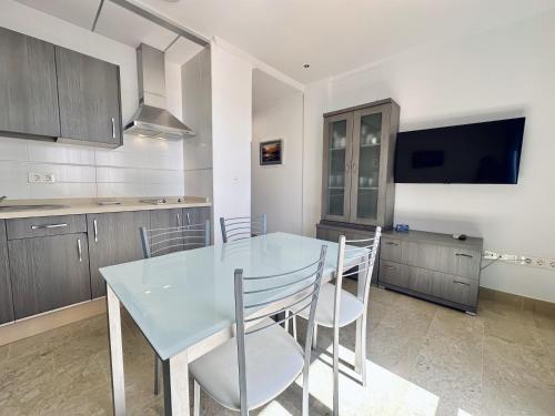 a kitchen with a table and chairs and a television at Hotel Apartamentos Marina Luz in Chipiona