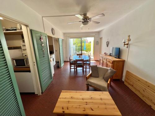 - un salon avec une table et un ventilateur de plafond dans l'établissement Appart RDC T3 proche plage accessible à pieds, au Barcarès