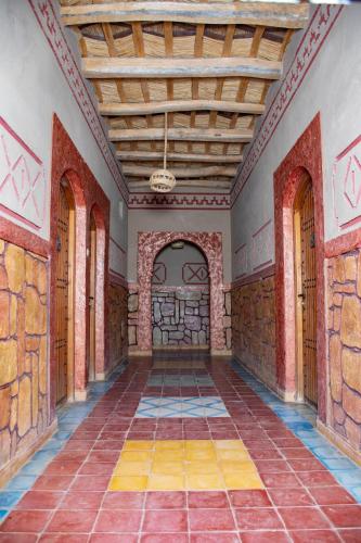 an empty room with brick walls and a wooden ceiling at Hotel Awayou in Bou Tharar