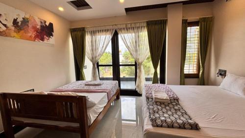 a bedroom with two beds and a window at Arjun Homestay in Hampi